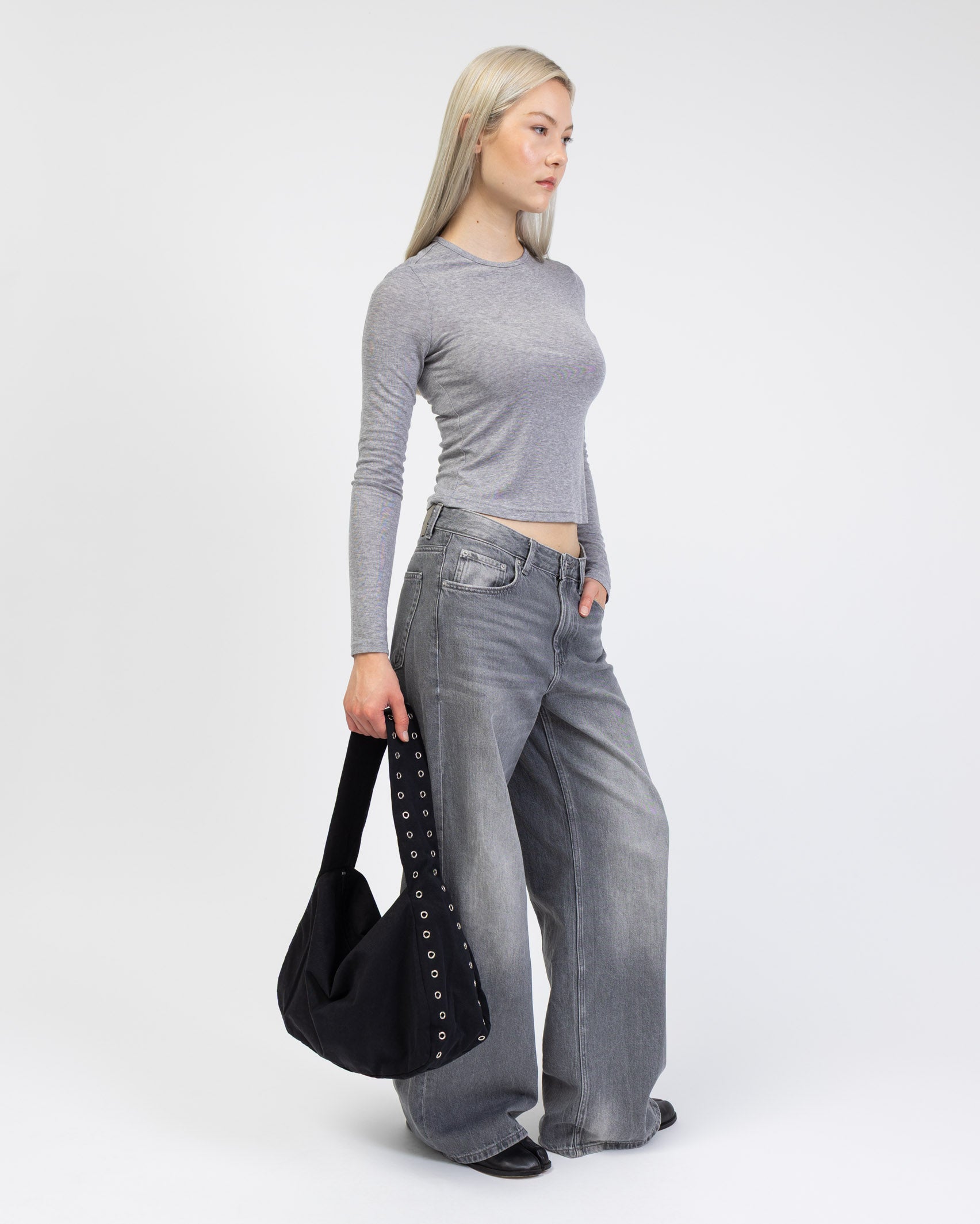 Tasche mit Ösendetails kombinet mit einem grauen Outfit