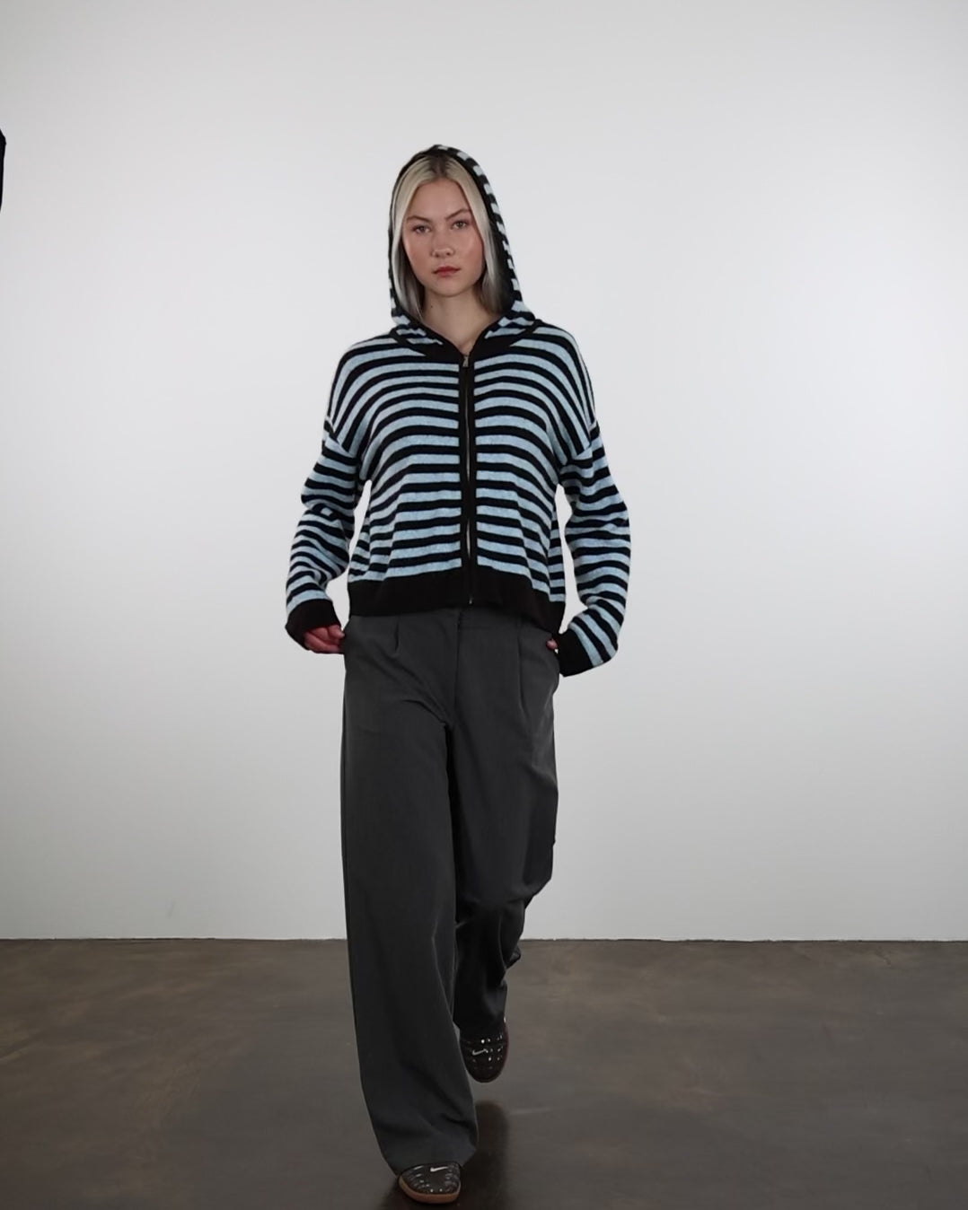 Gestreifte Strickjacke mit Kapuze in Bewegung
